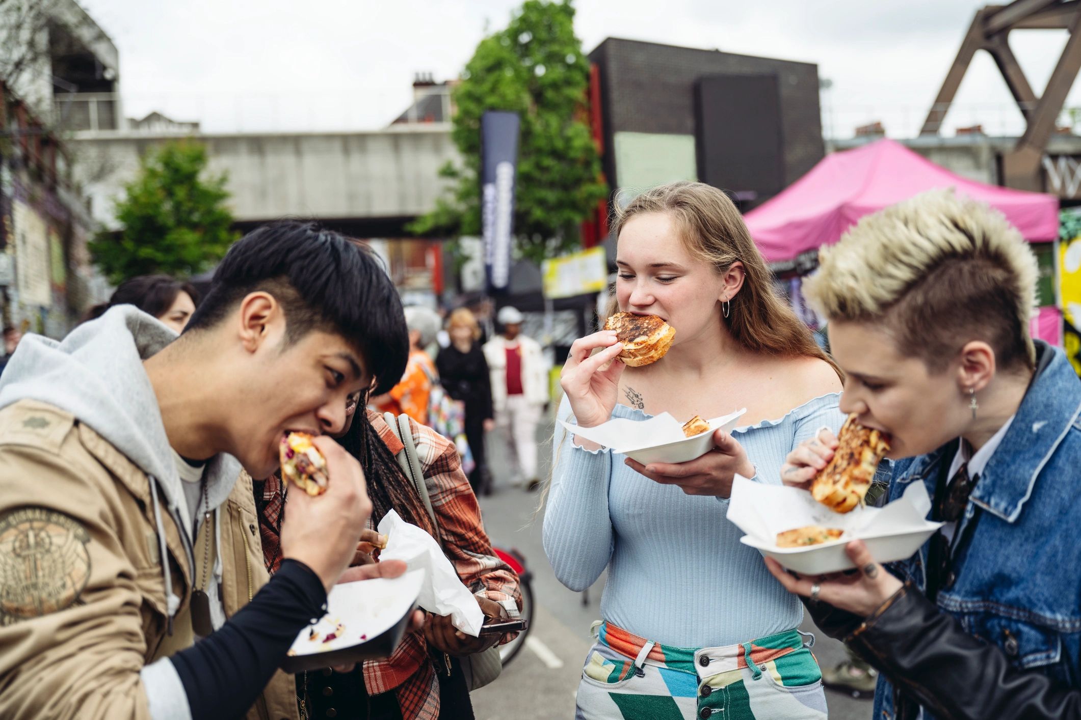 Friends eating street food outdoors in London