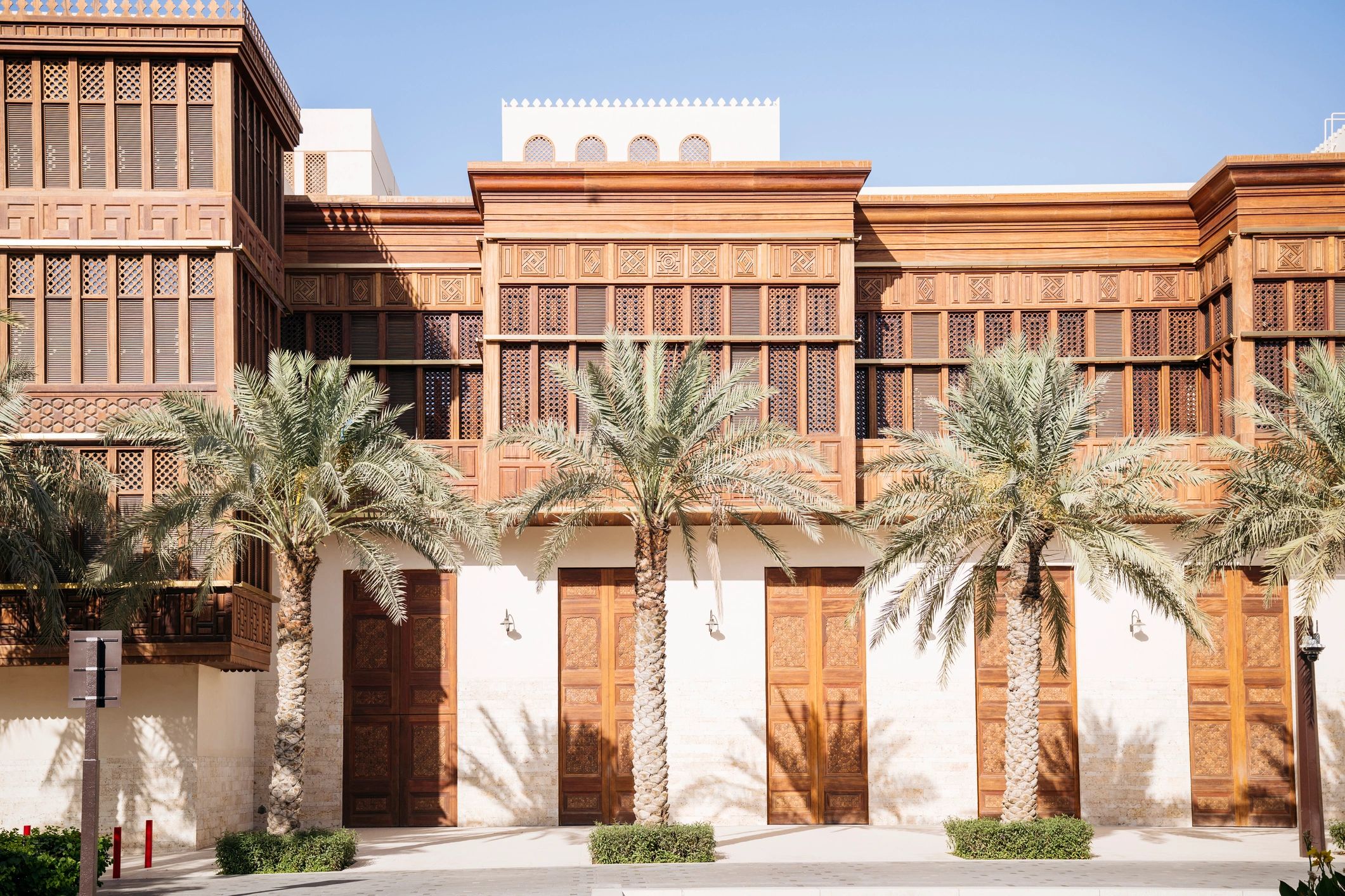 Traditional architecture and palm-lined walkway in Saudi Arabia