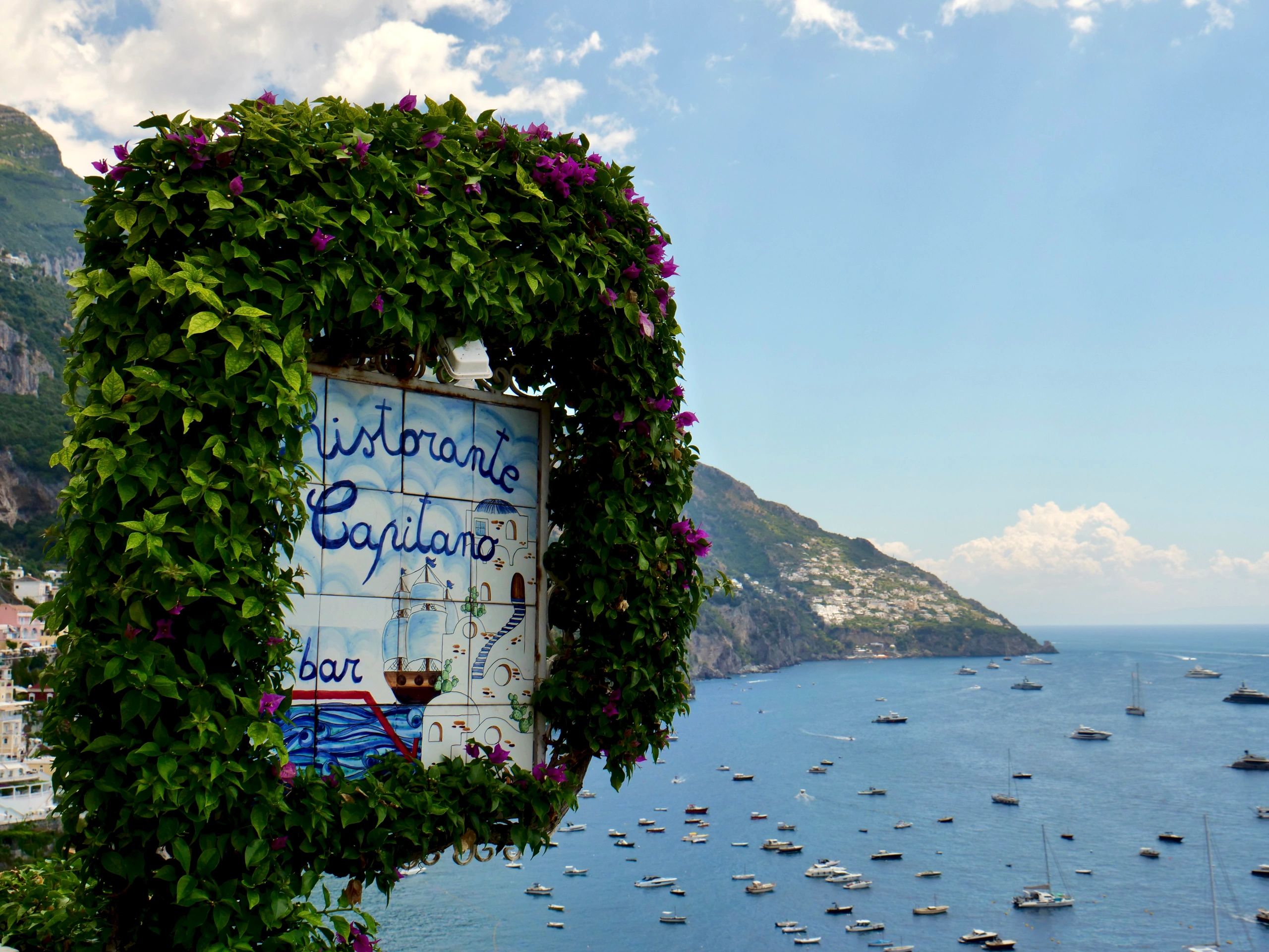 Positano restaurant sign with Amalfi Coast view