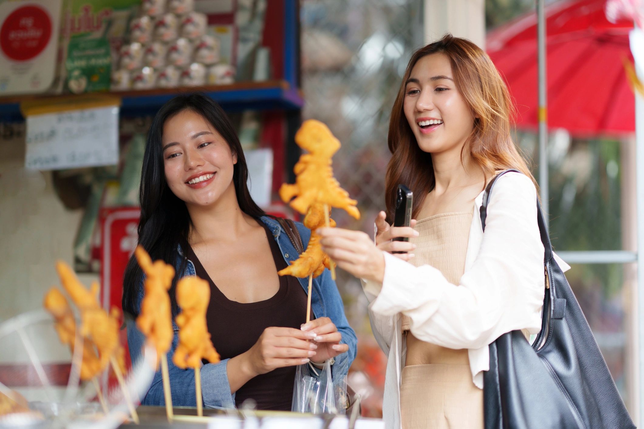 Friends enjoying street food at a market in Thailand