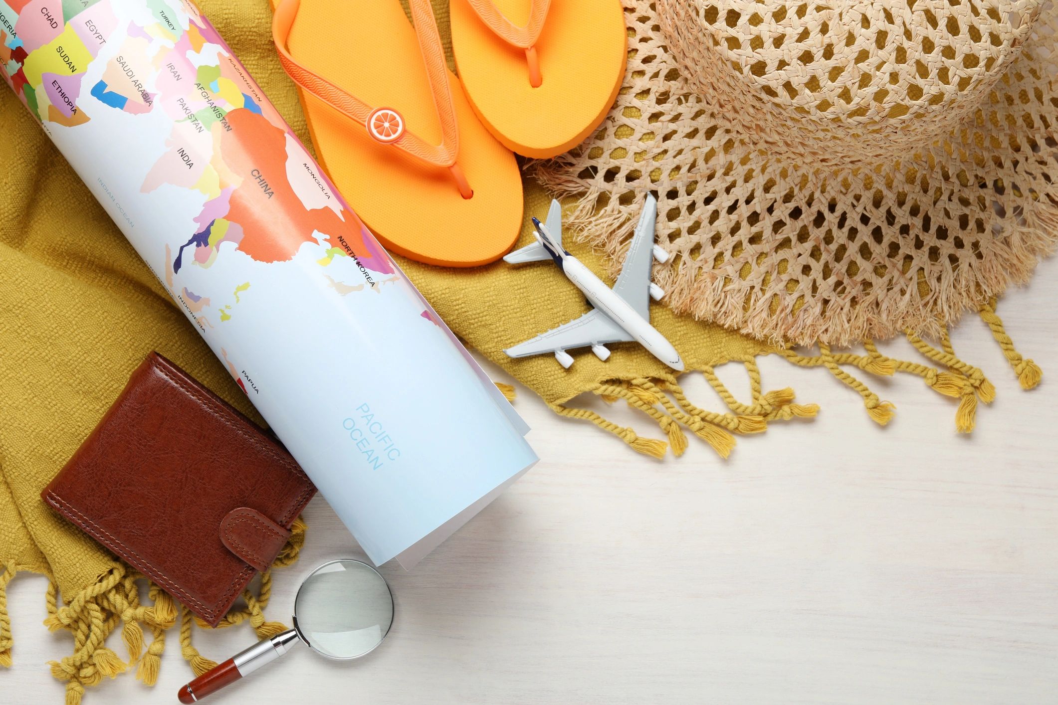 Travel planning flat lay with world map and accessories