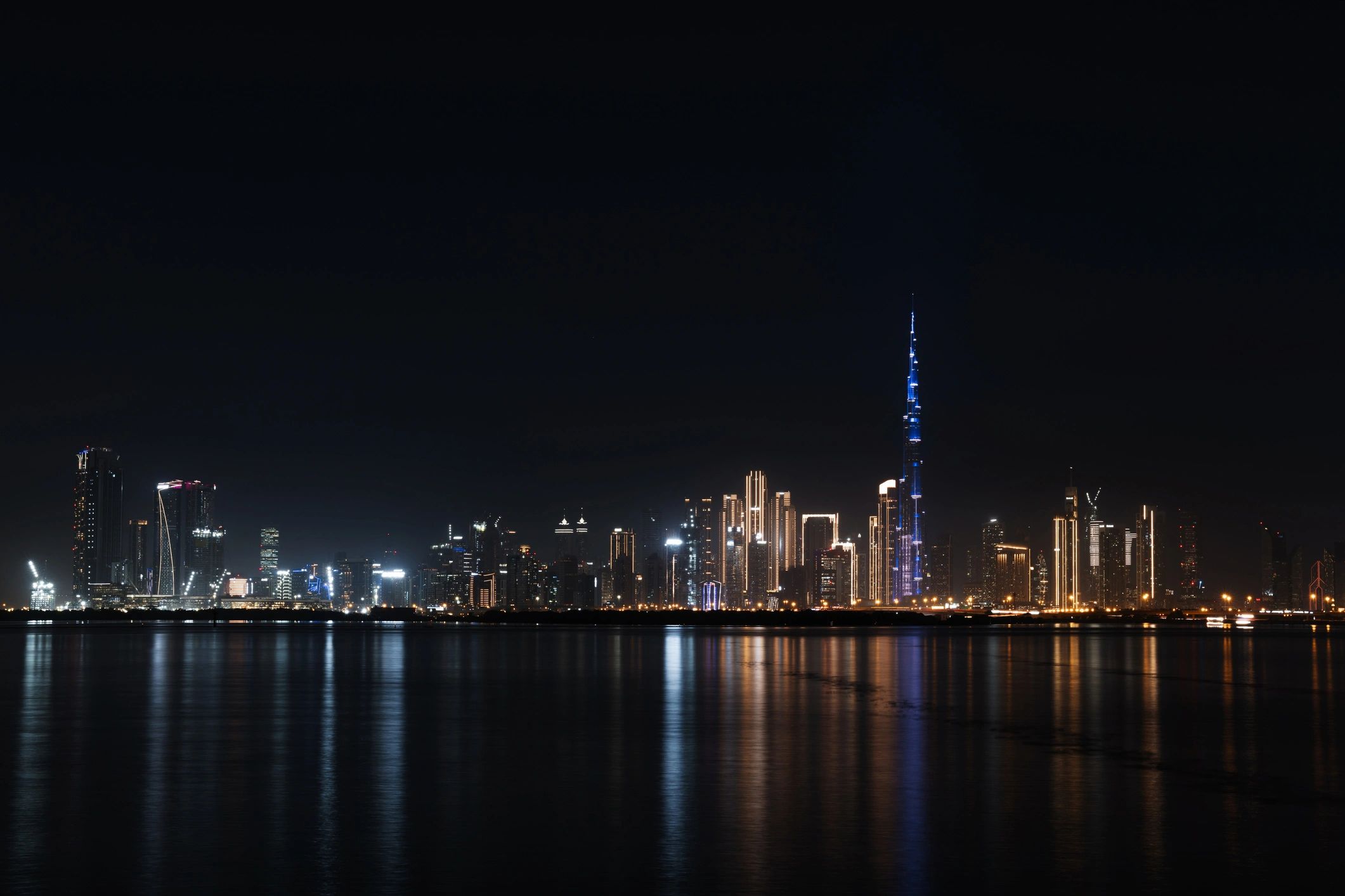 Dubai skyline at night with lights reflecting on the water